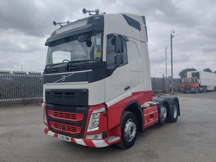 A Volvo FH tractor unit in white with a red lower cab